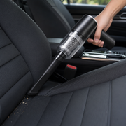 Cordless handheld vacuum cleaning a car seat